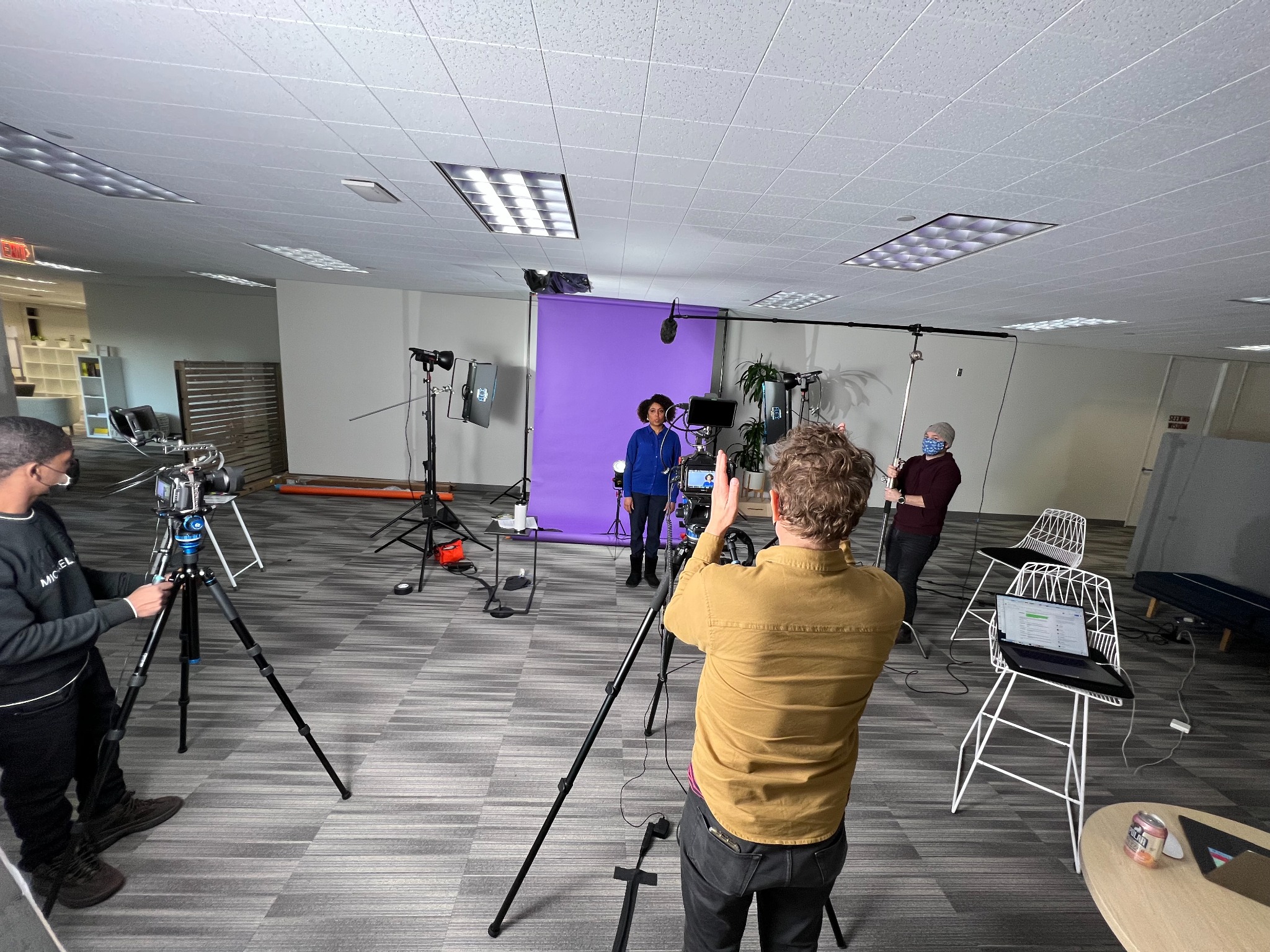 Behind the scenes of the Drift commercial set with cameras, lights, boom microphone and purple backdrop
