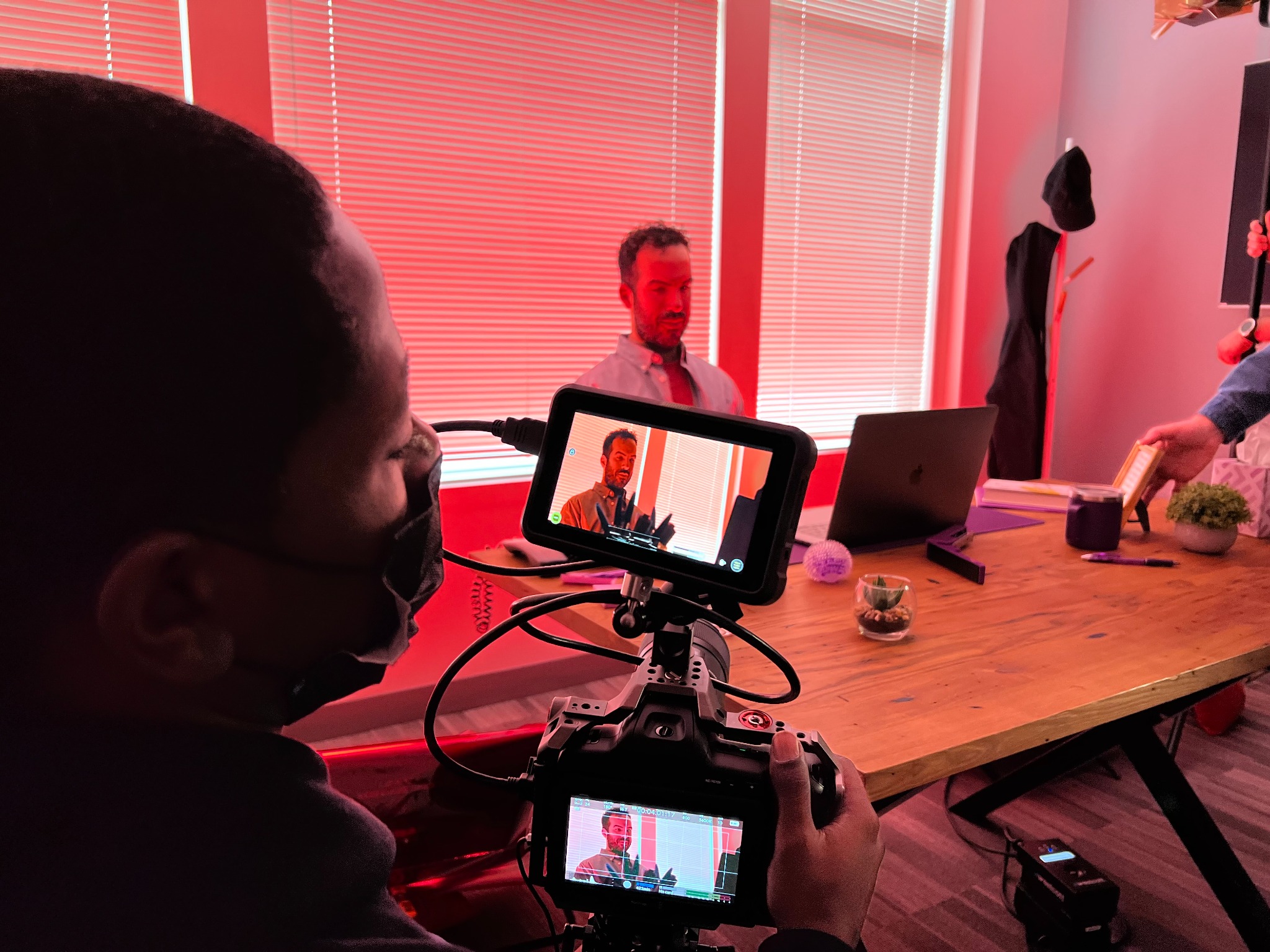 Camera operator framing an actor in red light