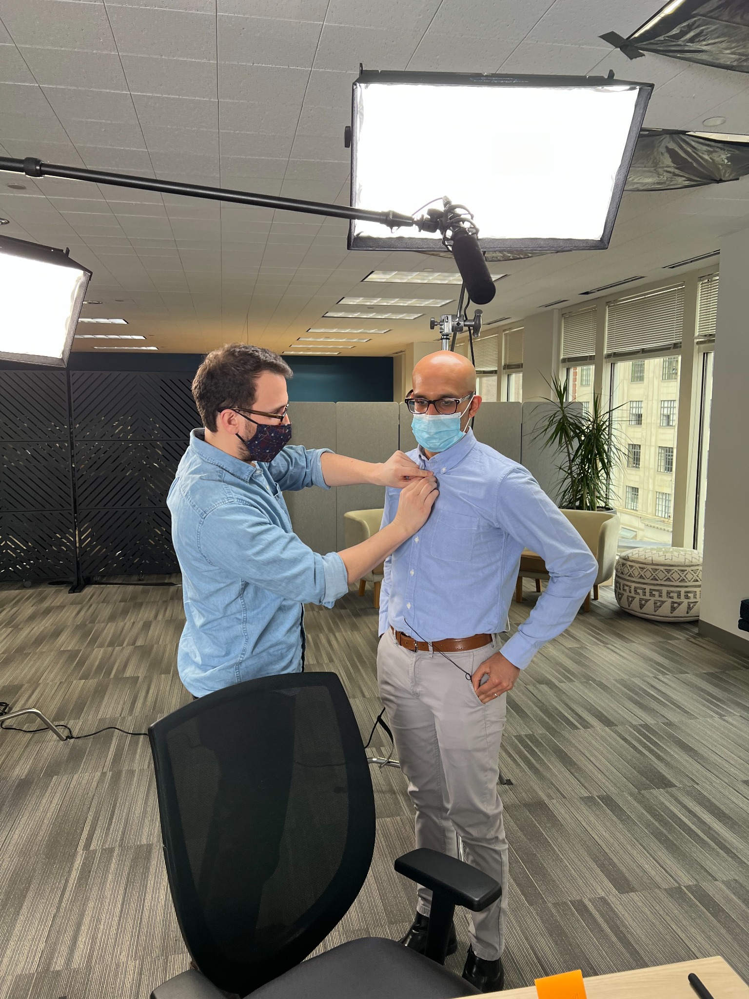Production team preparing an actor's lavalier microphone