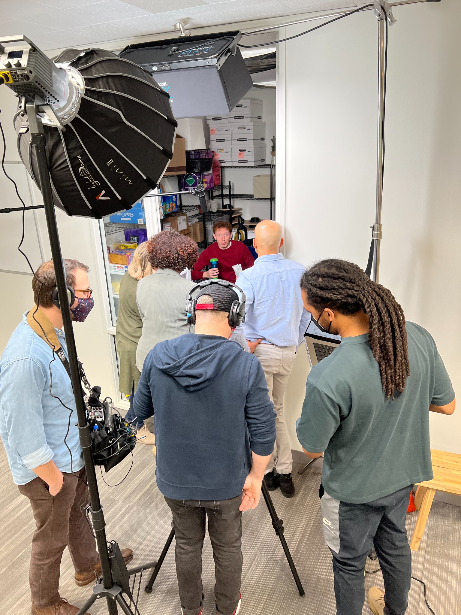 Crew and Cabrell reviewing a storage-room scene during production