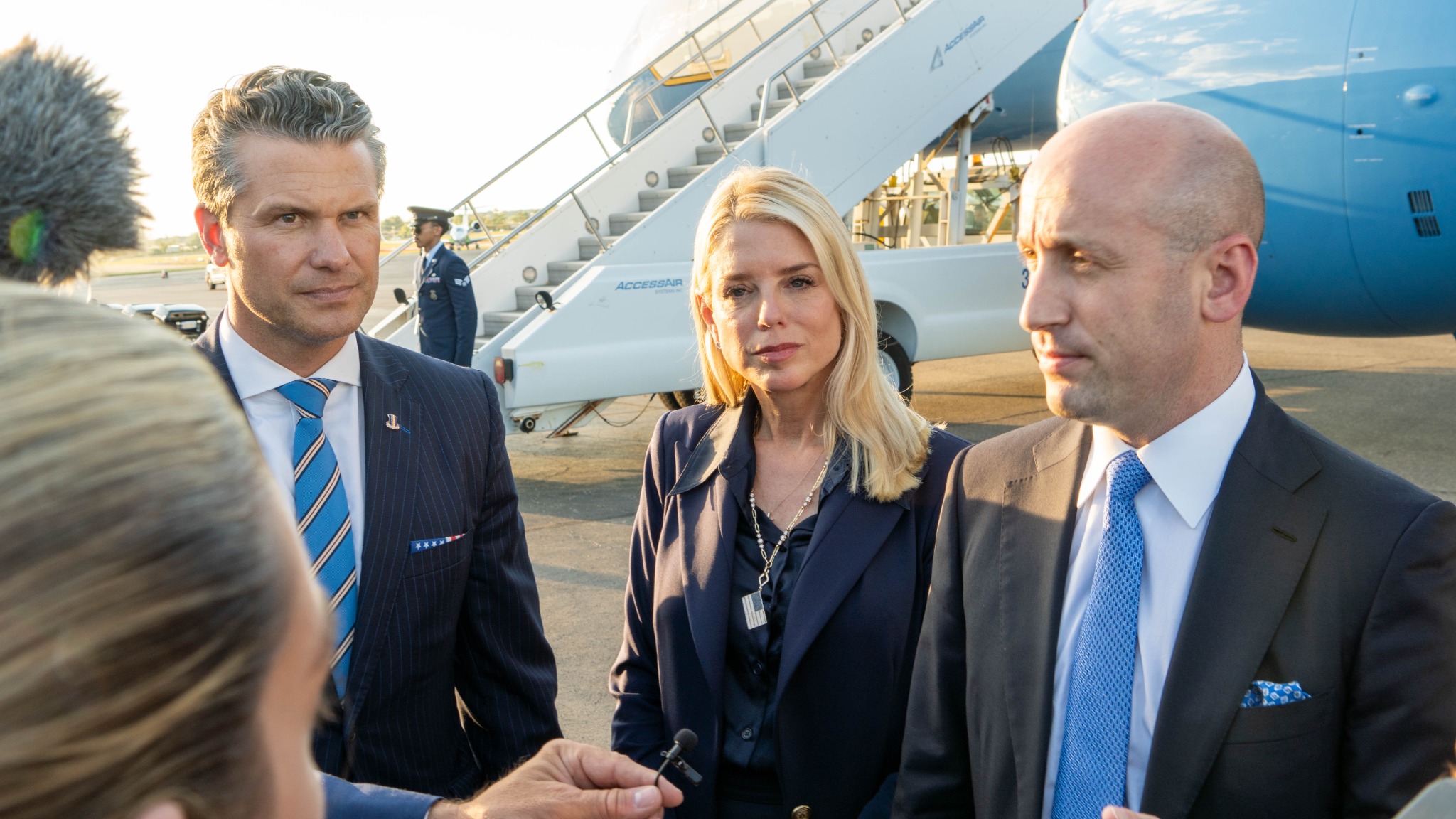 Executive press moment beside government aircraft